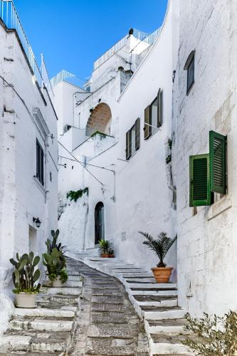 an alley with stairs in a white building at Ostuni Luxury Room in Ostuni
