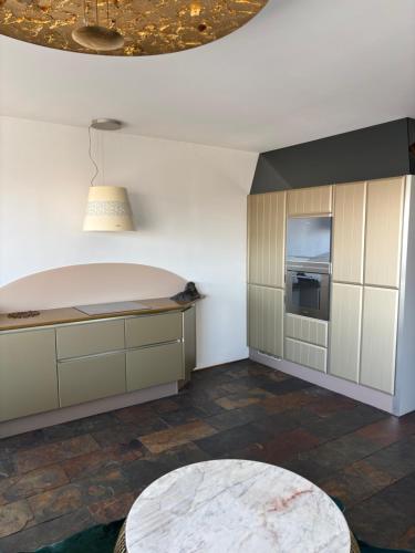 - une cuisine avec des murs blancs et une table dans l'établissement Panoramic Glam Appart à Neuilly-sur-Seine, à Neuilly-sur-Seine