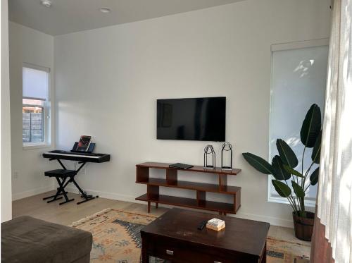 a living room with a flat screen tv and a piano at The Overlook in east Austin in Austin