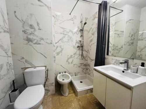 une salle de bain blanche avec des toilettes et un lavabo dans l'établissement Villa Estérel Large Studio with Terrace, à Cannes