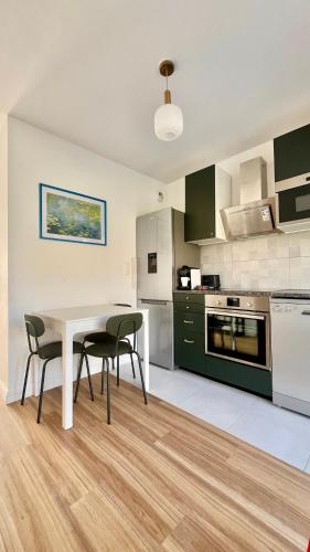 une cuisine avec une table et des chaises dans une pièce dans l'établissement Maison 88 Malakoff, à Malakoff