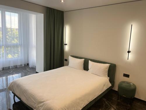 a bedroom with a bed with white sheets and a window at Люкс апартаменты .РАЙОН АВТОВОКЗАЛА,в ЖК Арена in Rivne