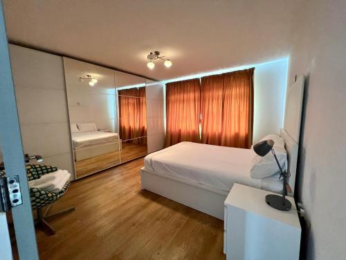 a bedroom with a bed and a desk and a mirror at The Premier Living Experience Entire 2-Bedroom Modern Apartment in Bromley