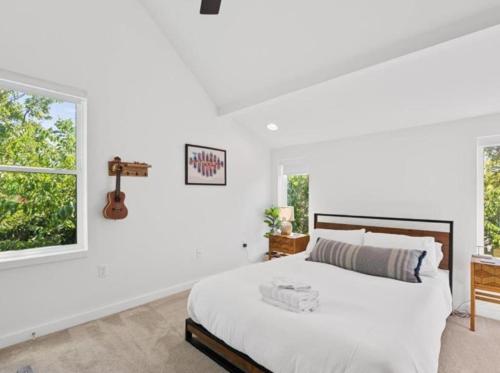 a white bedroom with a bed and a window at The Overlook in east Austin in Austin