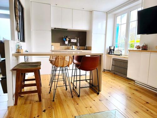 une cuisine avec un comptoir et des tabourets dans une pièce dans l'établissement Au calme, maison en pierres proche de la plage, au Guilvinec