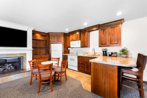 a kitchen with wooden cabinets and a table and chairs at Best Western Driftwood Inn in Idaho Falls