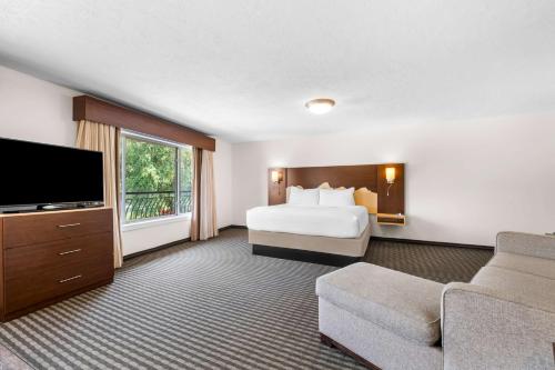 a hotel room with a bed and a flat screen tv at Best Western Driftwood Inn in Idaho Falls