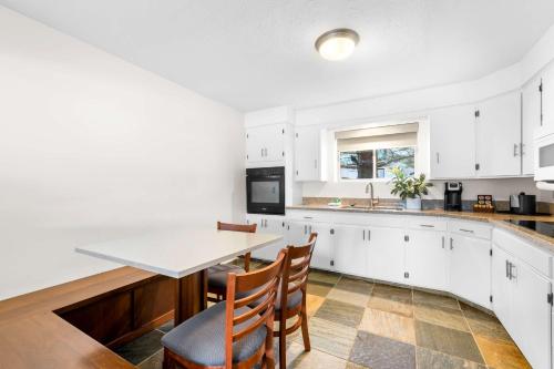 a kitchen with white cabinets and a table and chairs at Best Western Driftwood Inn in Idaho Falls