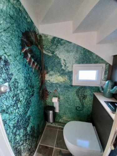 La salle de bains est pourvue d'une fresque murale représentant des poissons. dans l'établissement Au calme, maison en pierres proche de la plage, au Guilvinec