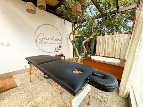 a black bench in a room with a tree at Hotel Boutique Recanto da Passagem in Cabo Frio