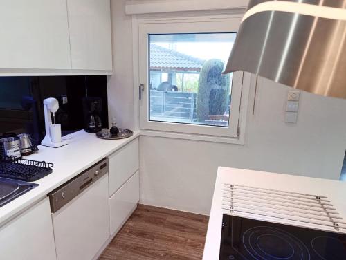 a kitchen with white cabinets and a window at Seferi4suite Ioannina in Eleoúsa