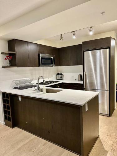 a kitchen with a sink and a stainless steel refrigerator at Amazing brand new 2bedr&2bathr in Richmond center in Richmond