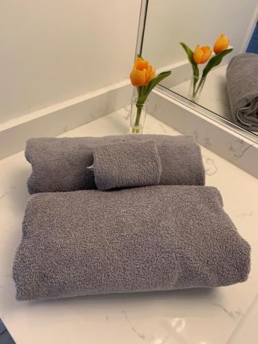 a pile of towels sitting on a table with flowers at Amazing brand new 2bedr&2bathr in Richmond center in Richmond