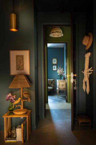 a hallway with a room with blue walls and a lamp at Maisons 322 - Maison L'Insolite in Le Bois-Plage-en-Ré
