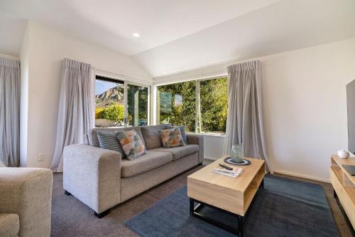 a living room with a couch and a table at Arrowtown Family Home with spa in Arrowtown