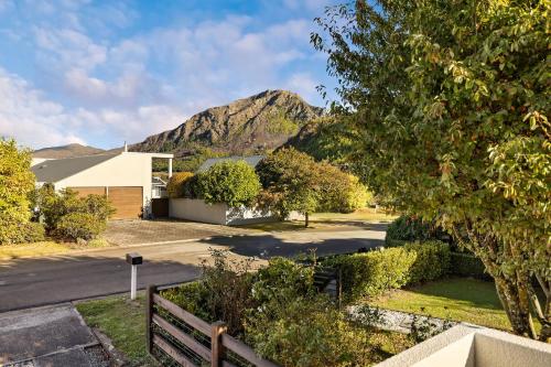a view of a house with a mountain in the background at Arrowtown Family Home with spa in Arrowtown