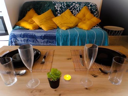 - une table basse avec des verres à vin et un canapé dans l'établissement Studio cosy sur le port, au Cap d'Agde