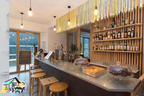 a restaurant with a bar with stools and bottles of wine at La Grange à Gaby in Engins