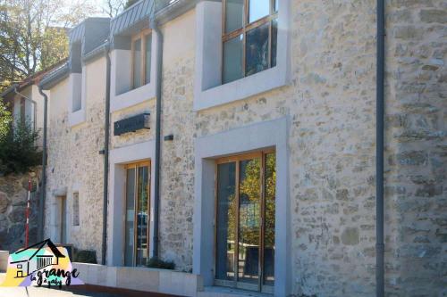 a brick building with large windows on a street at La Grange à Gaby in Engins