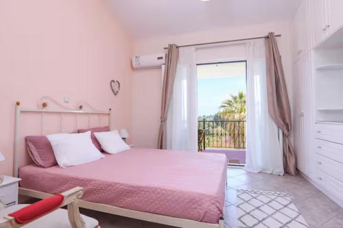 a bedroom with a pink bed and a sliding glass door at Maison See View in Kontokali
