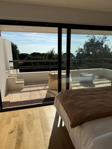 une chambre avec une grande fenêtre et une baignoire sur un balcon dans l'établissement Cannes Villa Sea View 5 Bedrooms - Villa Kanupi, à Vallauris