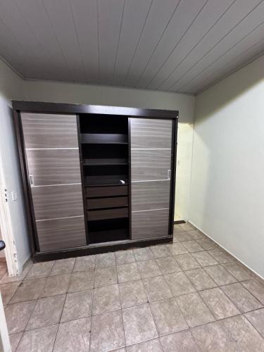 a room with a large closet with wooden doors at Casa do Marcus in Barra do Garças