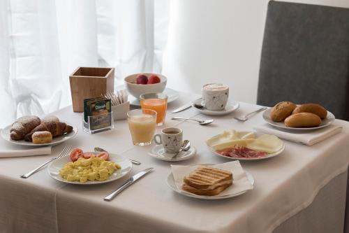 a table with plates of breakfast food on it at Hotel Villa Colico in Colico