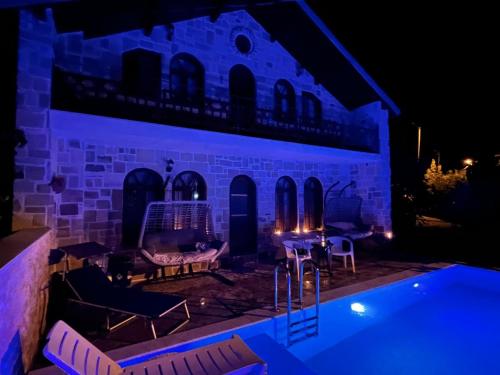 a villa with a swimming pool at night at Detached Stone Villa with Pool Sleeps 9 in Burhaniye