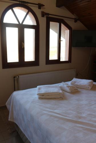 a bedroom with a white bed with two towels on it at Detached Stone Villa with Pool Sleeps 9 in Burhaniye