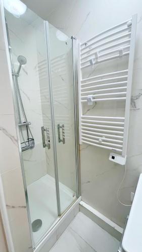 une douche avec une porte vitrée dans une salle de bain dans l'établissement Cozy Ap des Gobelins, à Paris