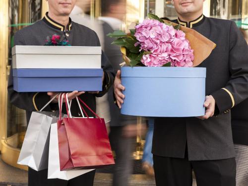 two men holding shopping bags and boxes of flowers at Emperador in Madrid