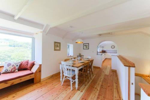 a kitchen and living room with a table and a couch at Riverside barn on private wildlife estate in Washaway