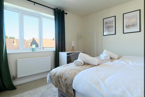 ein Schlafzimmer mit einem Bett und einem großen Fenster in der Unterkunft Home Private Parking, Sleeps 8, Contractors Welcome in Lemington