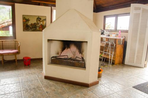 a fireplace in the middle of a living room at Pousada Aconchego Shangrilla in Penedo