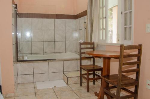 a kitchen with a table and a bath tub at Pousada Aconchego Shangrilla in Penedo