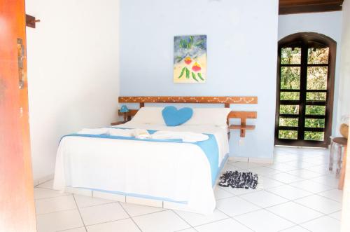 a bedroom with a bed with a blue heart on it at Pousada Aconchego Shangrilla in Penedo