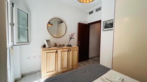 sypialnia z łóżkiem i lustrem na ścianie w obiekcie Homely Málaga Atarazanas w Maladze