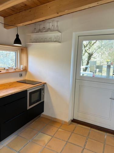 a kitchen with a sink and a door with a window at foresthaus in Glücksburg