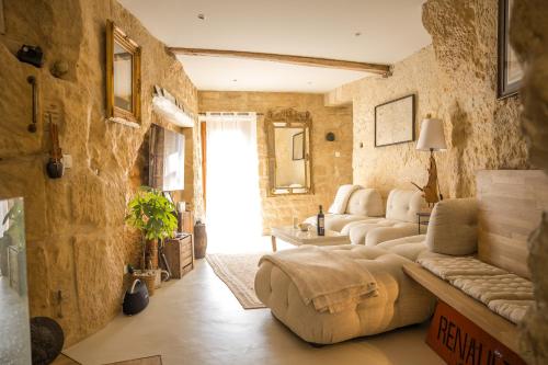 a living room with stone walls and couches at Chez Millouz - Triplex semi-troglodyte in Pontoise
