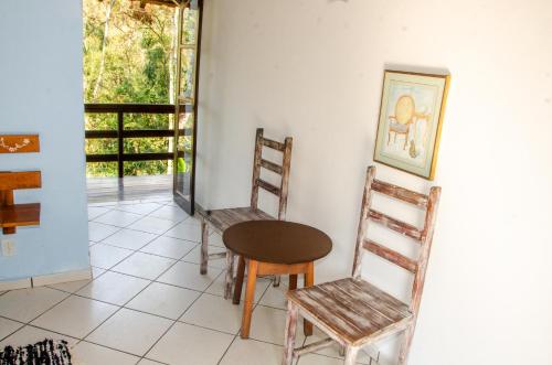 a room with chairs and a table and a window at Pousada Aconchego Shangrilla in Penedo