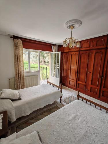 a bedroom with two beds and a chandelier at Apartamento con jardín in La Franca
