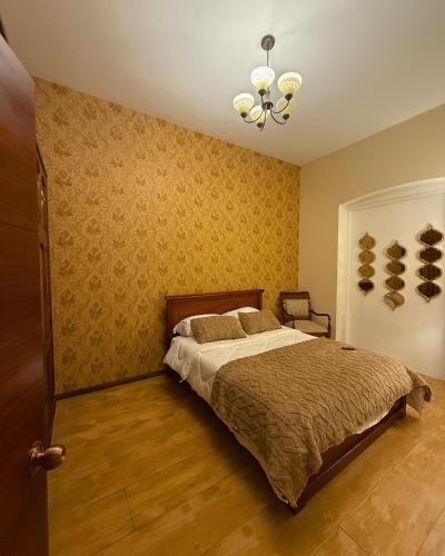 a bedroom with a bed and a chandelier at Casa Colonial Centro Histórico in Quito