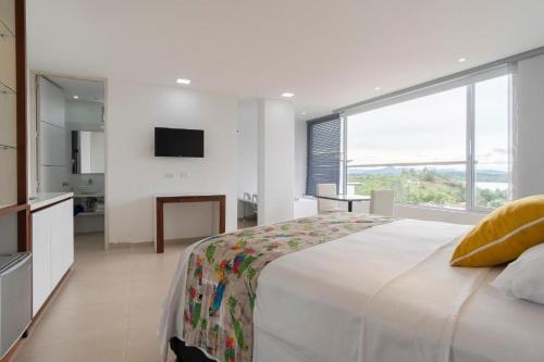 a bedroom with a large bed and a large window at Hotel Santorini in Guatapé