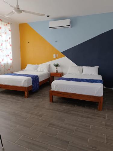 two beds sitting in a room with at Casa Mara in Río Lagartos