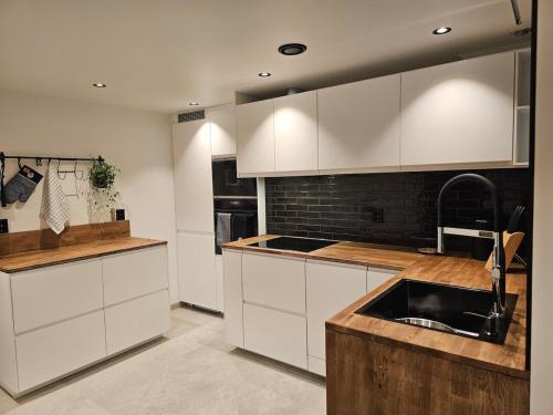 a kitchen with white cabinets and a sink at Over the Fjord in Leikanger