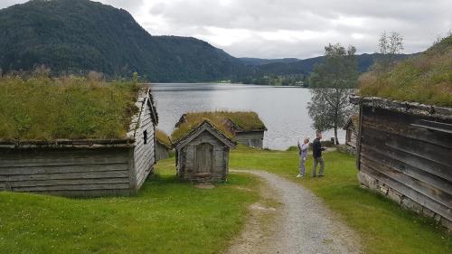 two people standing on a dirt road next to a lake at Over the Fjord in Leikanger