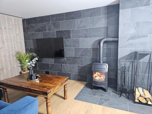 a fireplace in a living room with a wood stove at Over the Fjord in Leikanger