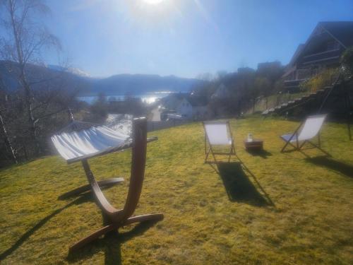 two chairs sitting in the grass in a field at Over the Fjord in Leikanger