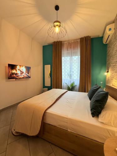 sypialnia z dużym łóżkiem z zielonymi ścianami i żyrandolem w obiekcie 80040GuestHouse w mieście Cercola