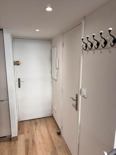 two white doors in a room with wooden floors at Central Studio with Mezzanine 3 minutes to Sea in Nice